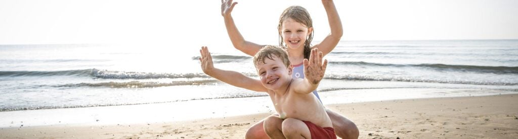 Children enjoying the beach together after restful nights of sleep with sleep apnea treatment.