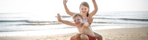 Children enjoying the beach together after restful nights of sleep with sleep apnea treatment.