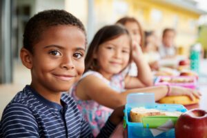 Children sitting at lunch in school with healthy smiles.