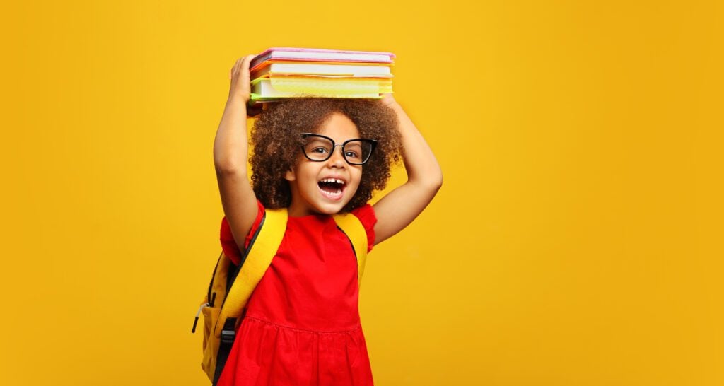 A young girl smiling, ready for picture day at school.