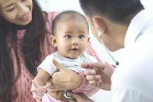 A baby recieving early pediatric dental treatment.