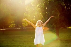 A child standing in a park during golden hour.