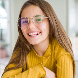 A little girl smiling happily with healthy teeth.